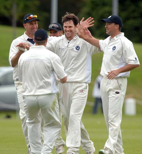 Craig Wright is mobbed by team-mates after taking another early wicket