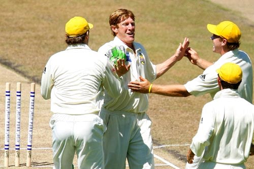 Mathew Inness is mobbed by his team-mates after dismissing Brad Hodge