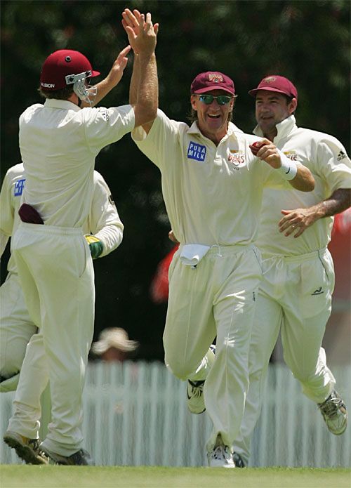 Andy Bichel celebrates taking a catch off Ashley Noffke