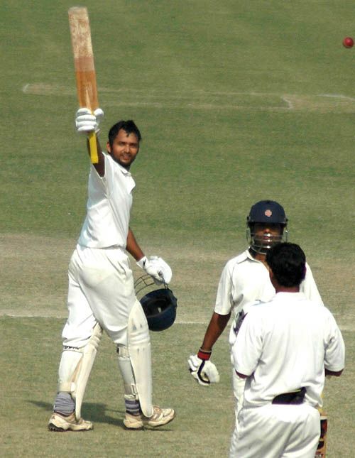Hemal Watekar raises his bat after scoring his second century of the match