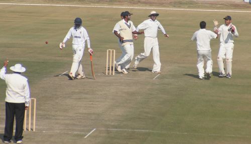 Yogesh Takawale walks back to the pavilion while the Himachal Pradesh team celebrate 