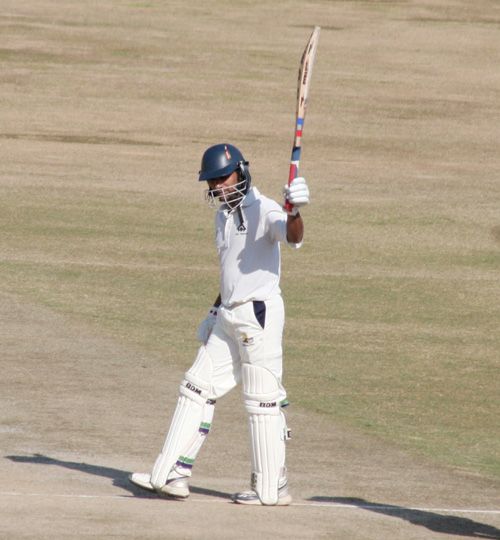 Hemant Dogra raises his bat after reaching his half-century