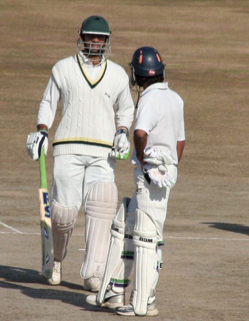 Mukesh Sharma talks to his team-mate after completing his century
