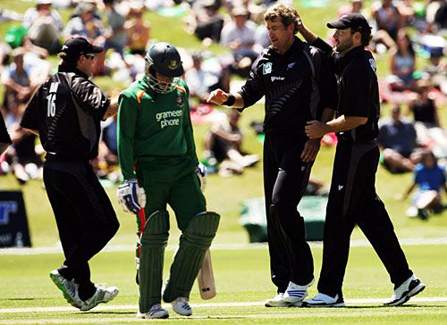 Team-mates congratulate Jacob Oram on dismissing Tushar Imran for one