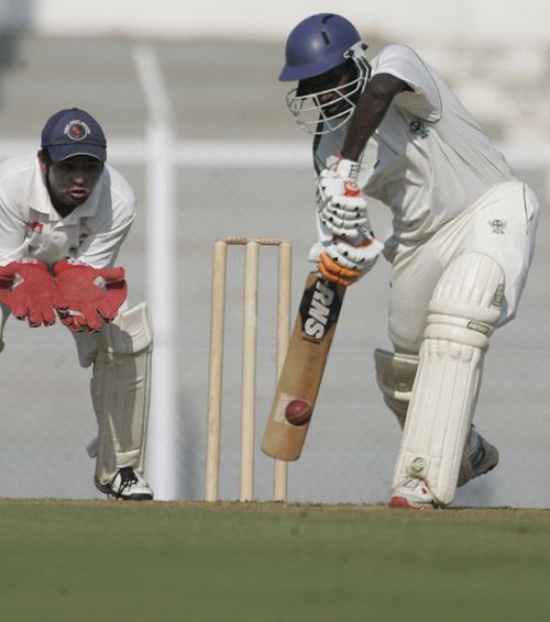 Harshad Rawle defends the ball as Parthiv Patel looks on