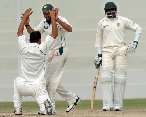 Samiullah Khan is congratulated by Shahid Afridi after he dismissed Brendan Taylor (unseen) while Hamilton Masakadza looks on