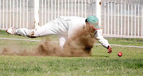 The dust flies as Hiren Varaiya pulls off a fine save on the boundary