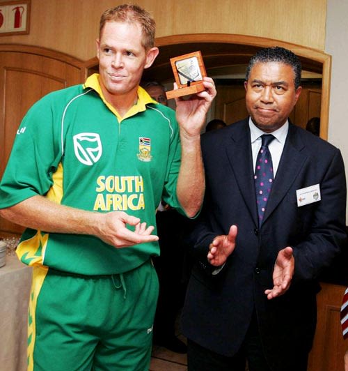 Shaun Pollock displays a medallion as Cricket South Africa president Norman Arendse looks on
