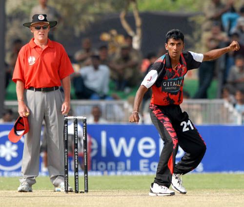 Upul Chandana bowls while umpire Jeff Evans keeps close watch