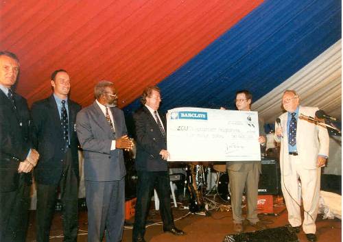Simon King presents a cheque for Zim$5 million to Dave Everington