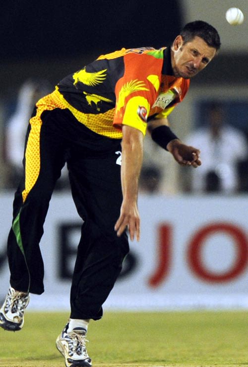 Michael Kasprowicz bends his back as he sends down a delivery