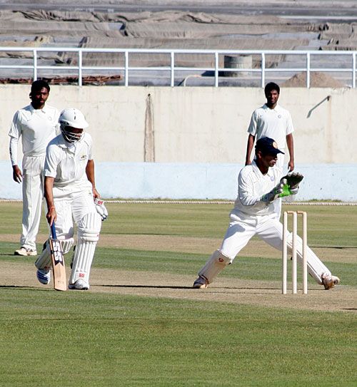 Kerala keeper Vinan Nair fields the ball as Sangram Singh returns to the crease