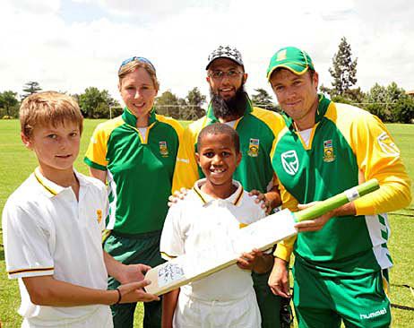 Cri-zelda Brits, Hashim Amla and AB de Villers hand an autographed bat to school children