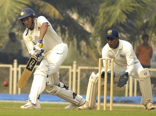 Ajit Agarkar gets in line to defend the ball