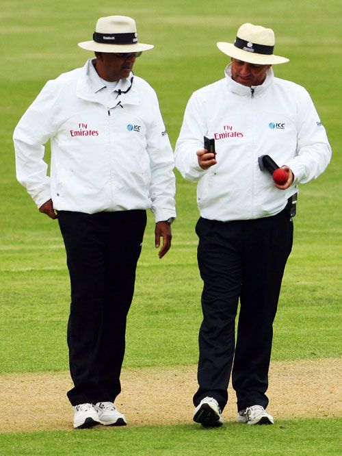 Umpires Amish Sahiba and Mark Benson have a look at the light meter