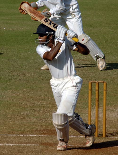 Karnataka's B Akhil punches the ball through the off side