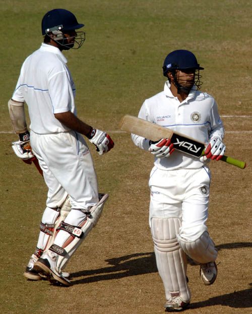 Cheteshwar Pujara and Shitanshu Kotak look on as the ball sails to the boundary