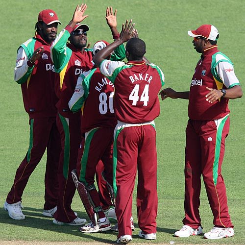 Lionel Baker is congratulated by team-mates after dismissing Brendon McCullum