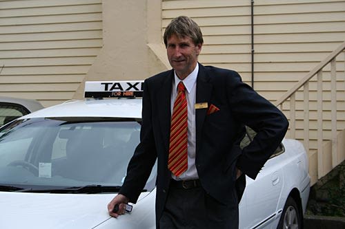 Ewen Chatfield poses beside his taxi