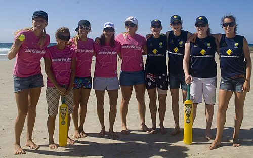 Australian surfers and cricketers pose for photos at a beach cricket game