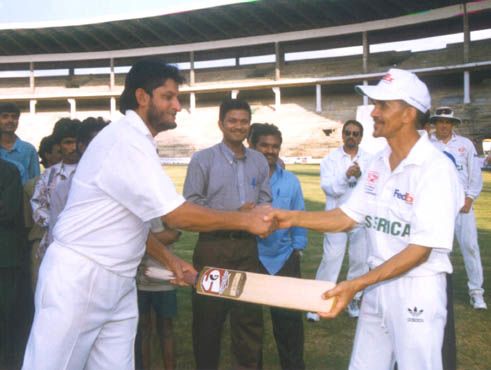 Sandeep Patil handing over the bat of friendship to O Henry SA captain