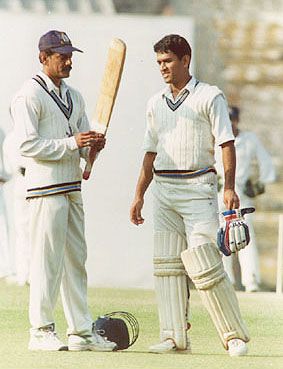 Utpal Chatterjee taking a look at MS Dhoni's bat in between the overs