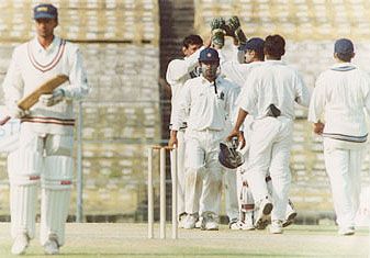 Chatterjee celebrates with his team mates after taking a Bihar wicket