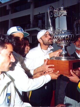 Moment of joy: Skipper Shahid Anwar plants a kiss on the trophy