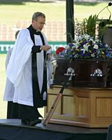 A cricket bat rests next to the coffin of David Hookes