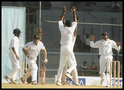 Kulkarni high-fives with Dighe after trapping Hayden in front