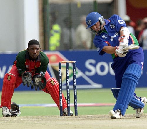 Namibian batsman Daniel Keulder drives a delivery watched by Zimbabwe wicket keeper Tatenda Taibu at the Harare Sports Club