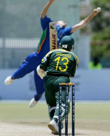 Bjorn Kotze jumps for a ball batted back by Yousuf Youhana