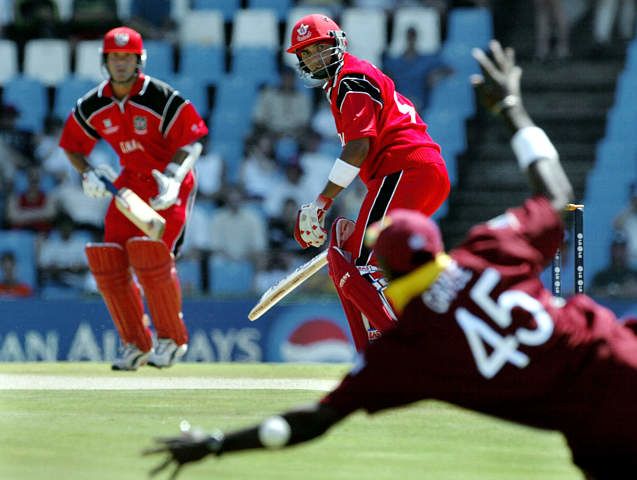 Ishwar Maraj looks on anxiously as Chris Gayle makes an attempt to catch him