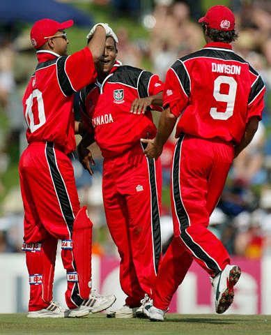 Nicholas de Groot is congratulated by teamates Asish Bagai and John Davison after he bowled Brian Lara