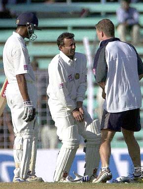 Mongia grimaces in pain after being hit on the glove by Gillespie