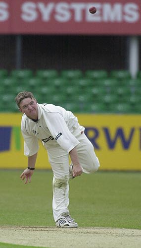 Graeme Bridge gives the ball a tweak in his bowling spell