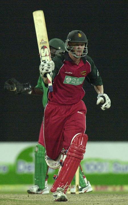 Zimbabwe top scorer Douglas Marillier waves his bat in jubilation while running to complete his 100 runs