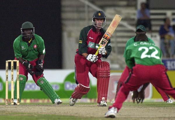 Kenyan bowler Collins Obuya (R) takes catch of Zimbabwe's Gavin Rennie (C) on his own bowling