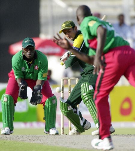 Shoaib Malik (C) drives for a boundary off Joseph Angara (R)
