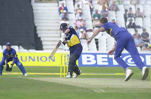 Powell drives the airborne Giddins through the covers