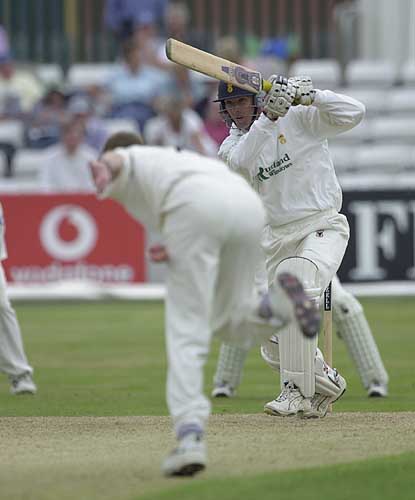 Chris Bassano punches a drive back past bowler Andy Harris