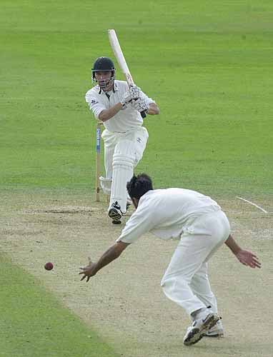 David Leatherdale drives a delivery back past bowler Malik
