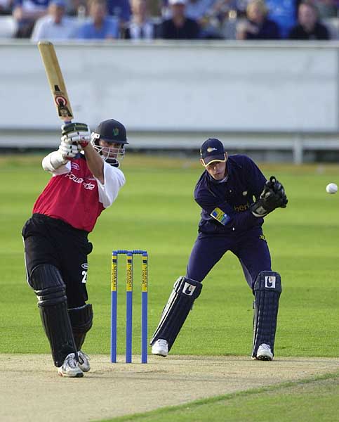 Glamorgan's Ian Thomas drives the Durham bowling as keeper Pratt looks on