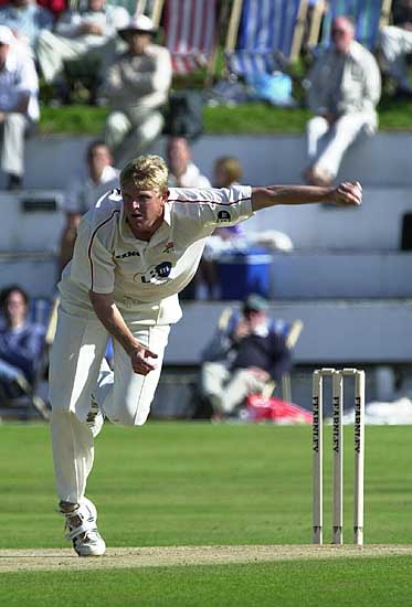 Peter Martin bowling against the backdrop of the Blackpool deckchairs