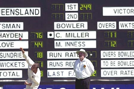 Umpire Torpey watches Miller bowl