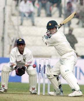 Paul Strang shapes to cut the ball as Dahiya watches
