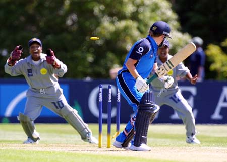 Kathryn Leng looks behind to see the bails flying after being bowled