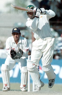 Trevor Madondo drives the ball on the up as Dahiya watches