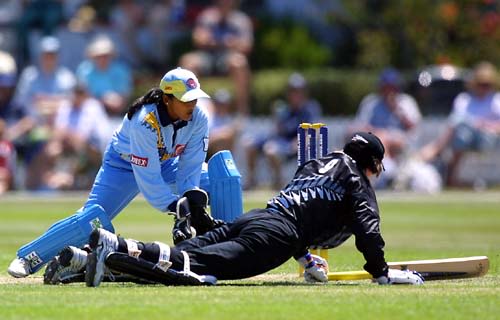 Anna O'Leary dives to the crease as Indian wicketkeeper Anju Jain gathers the ball