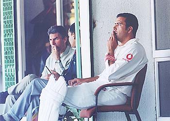 James Ormond, all padded up, smokes contemplatively in the pavilion